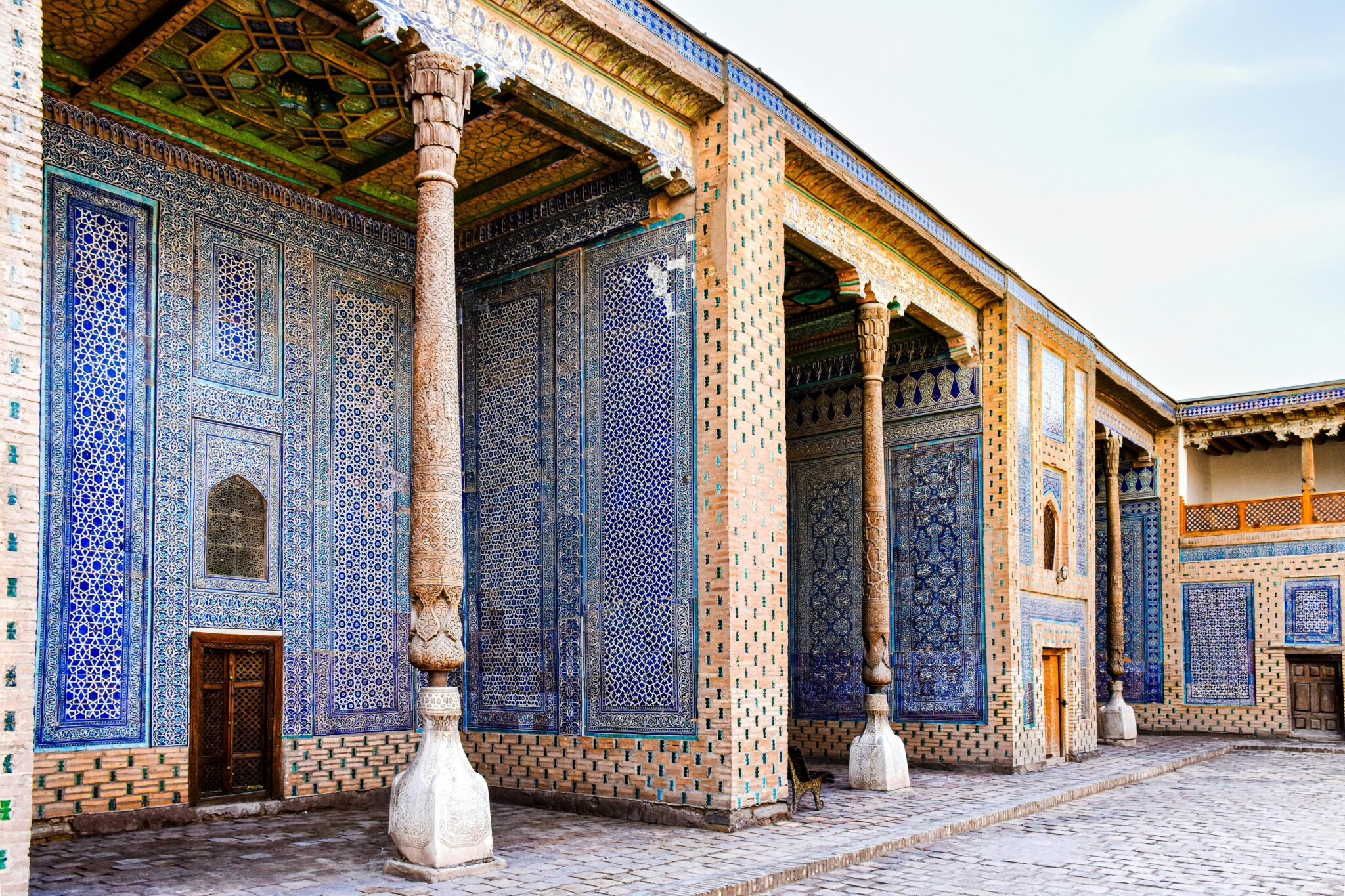 A detailed view of the beautiful and ornate facade of Toshhovli Palace in Khiva, showcasing traditional Uzbek architecture.