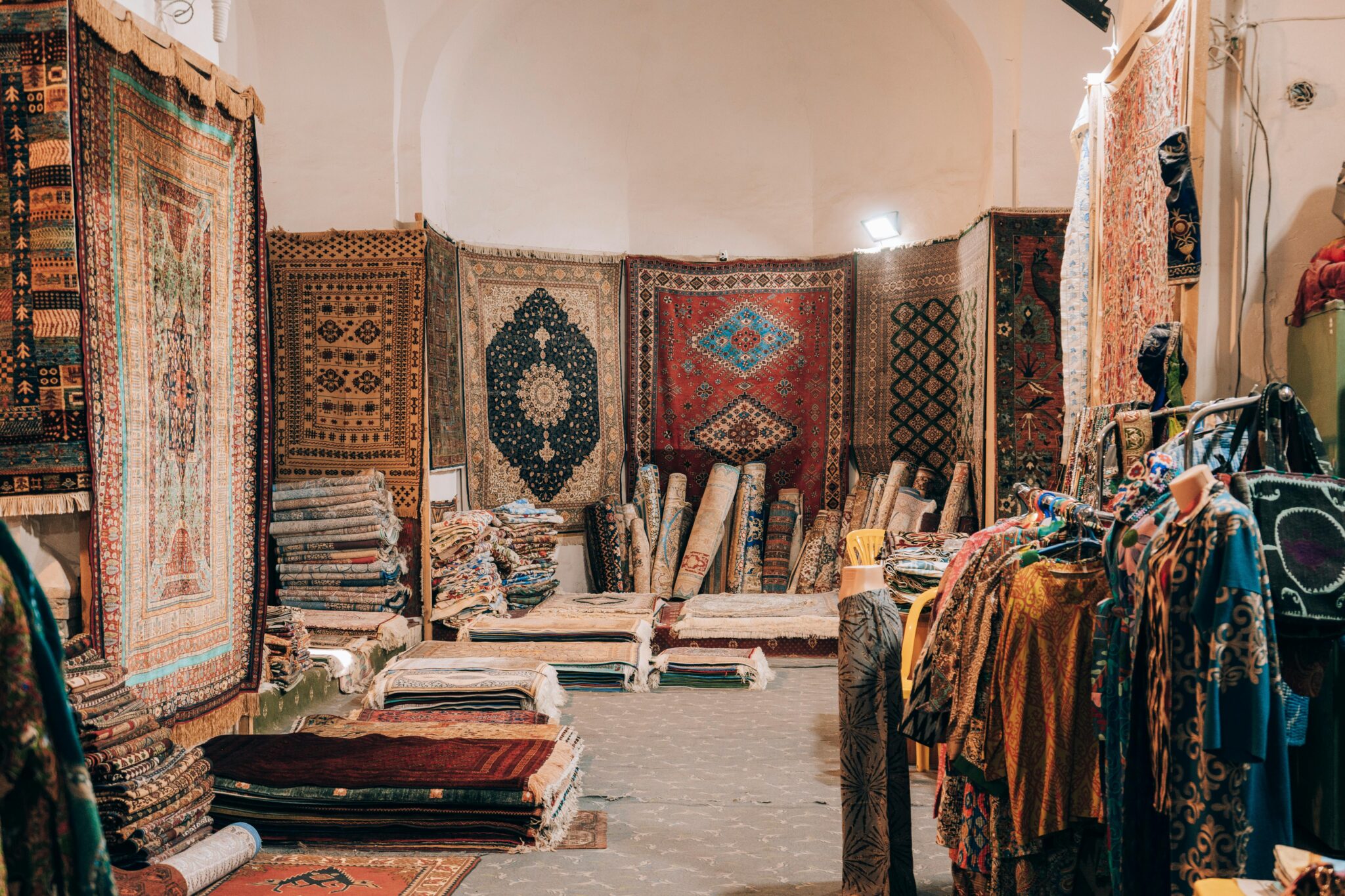 Explore intricate carpets and vibrant textiles in a Bukhara market shop.
